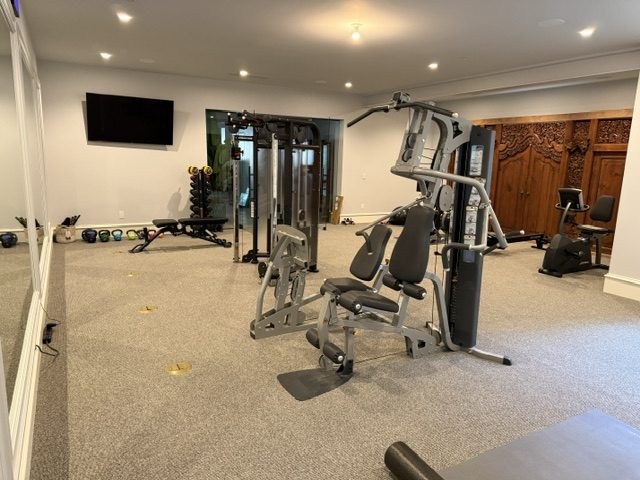 Strength floor with cable stations, benches, and a wall-mounted display