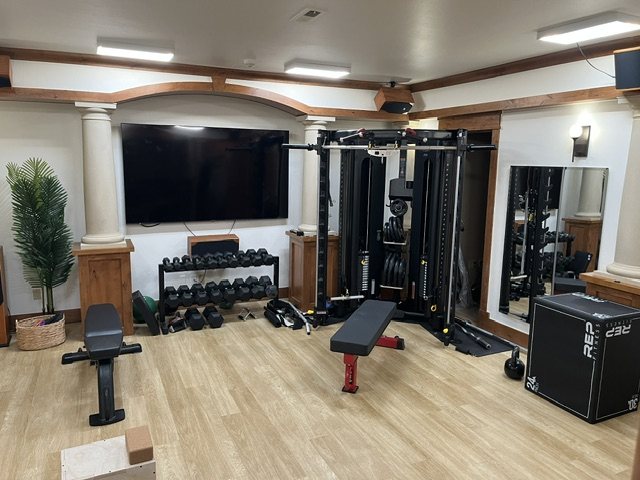 A completed luxury home gym with functional trainer and free weights