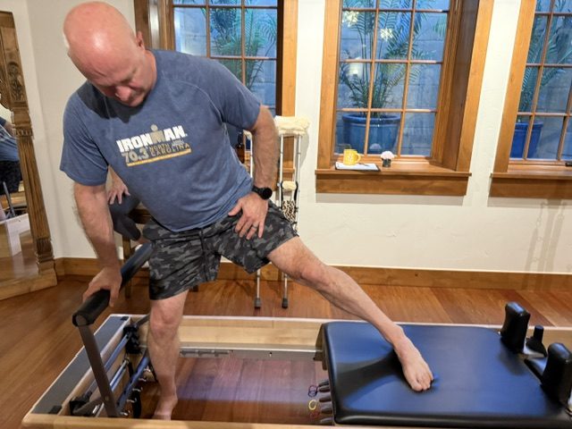 Assisted mobility work on a Pilates reformer